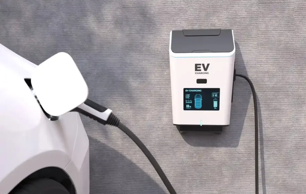 Wall-mounted ev charger connected to an electric car, showing a digital charging status display.