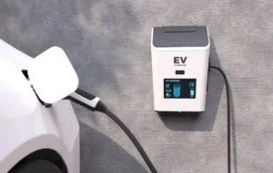 Wall-mounted ev charger connected to an electric car, showing a digital charging status display.