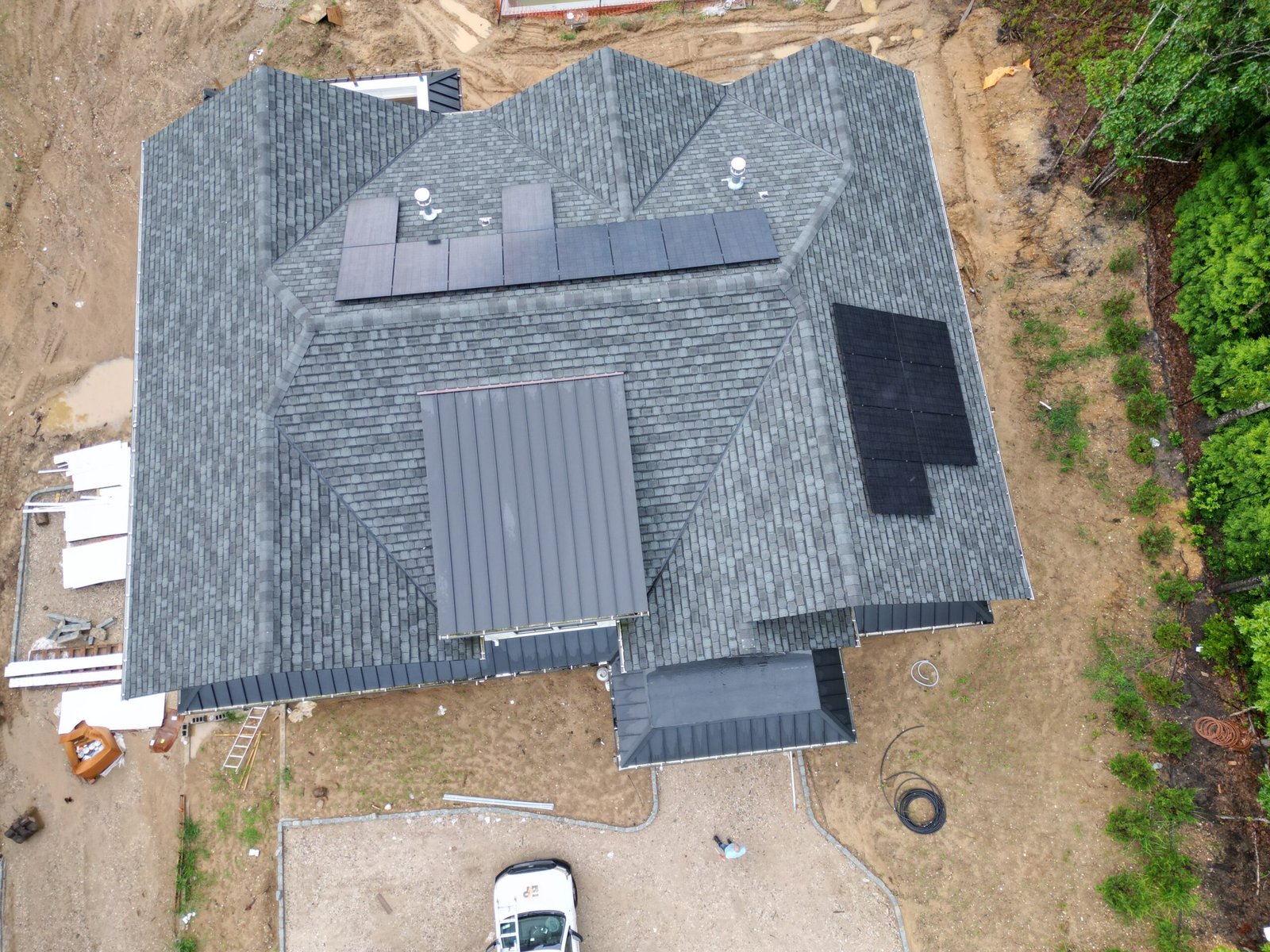 Do trees affect solar panels? Home solar panels on a shaded Long Island roof under tall oak trees
